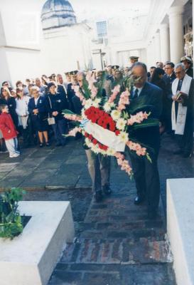 El Centro de Veteranos de Guerra colocando la ofrenda floral al pie del monumento en el cementerio