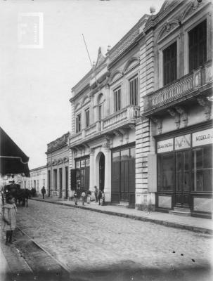 Calle Mitre en la cuadra comprendida entre Urquiza y 9 de Julio (vereda impar) Casa de alto con mástil: //Altos de Frugone// posteriormente fue sede de los Tribunales