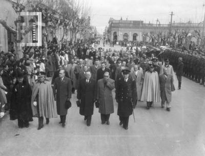 Comitiva oficial desfilando por calle Mitre frente a la plaza. José Leo Morteo, Padre Torti, Militares