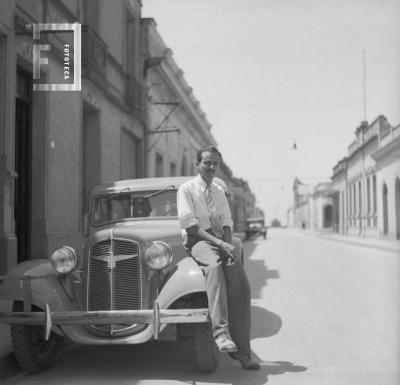 César C. Bustos (Pocholo) sentado en guardabarros auto