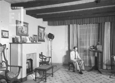 Estudio Foto Bustos, Nación 124. César Carlos Bustos (Pocholo) sentado leyendo