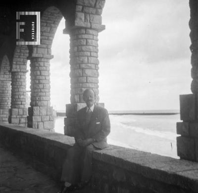 César Bustos sentado con fondo mar, durante viaje Grupo Arroyo del Medio a Mar del Plata, Recital en Club Atlético, 24 de febrero 1951