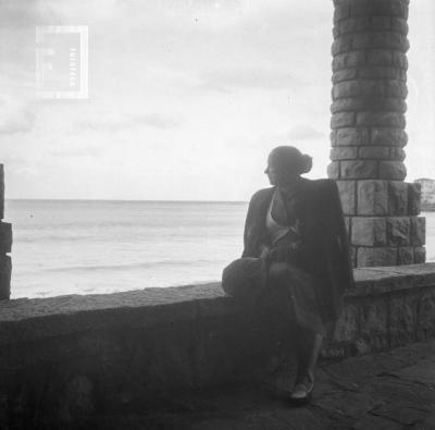 Dama sentada con fondo mar, durante viaje Grupo Arroyo del Medio a Mar del Plata, Recital en Club Atlético, 24 de febrero 1951