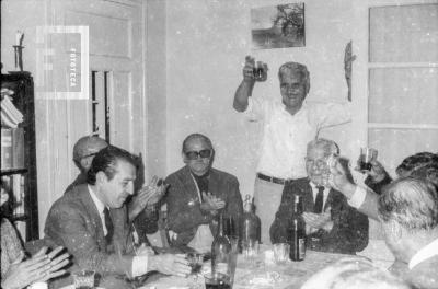 Astul Urquiaga brindando en reunión
