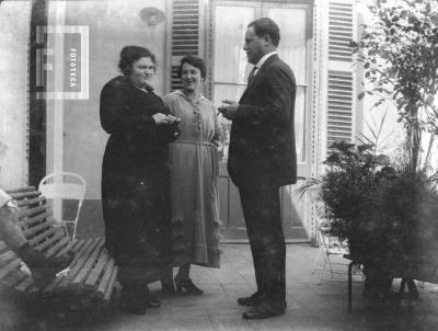 Dos damas y un señor en patio