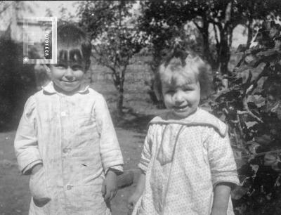 Niño y niña en fondo con arboles