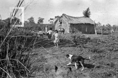 Niños y perro frente a rancho en la isla