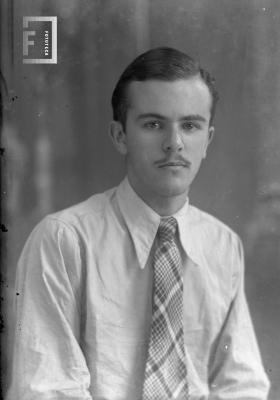 César Carlos Bustos (Pocholo) joven, de camisa y corbata