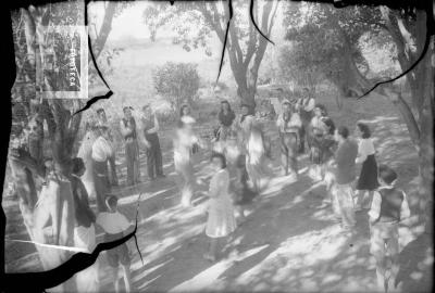 Grupo en el campo, rueda alrededor de pareja bailando