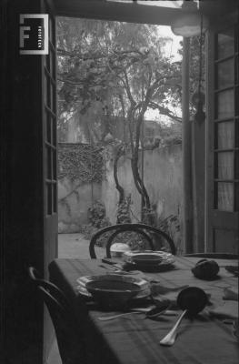 Interior comedor con mesa y puerta abierta a patio