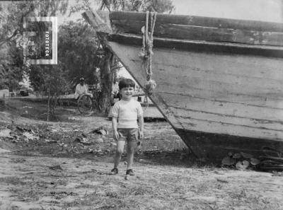 César Alberto Bustos en la costanera junto a proa de lancha abandonada
