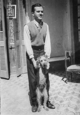 César Carlos joven de cuerpo entero con perro pequeño