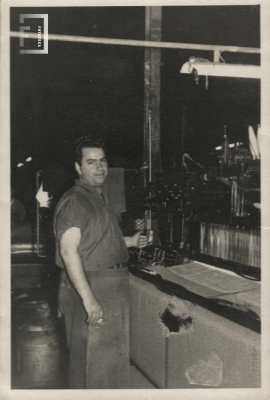 Retrato trabajador posando junto a su telar 