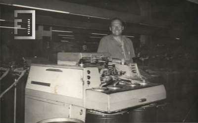 Trabajador junto a su máquina 