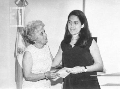 Marta García, hermana del poeta Ginés García, entrega a María Eugenia Maiztegui