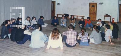 Grupo sentado en círculo en escenario del Teatro Municipal