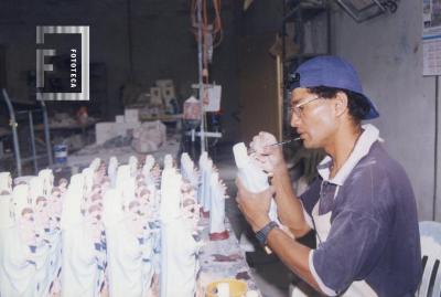 Artesano decorando imágenes de la Virgen del Rosario
