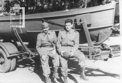 Dos militares junto a embarcación