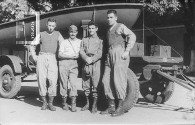 Cuatro militares junto a embarcación