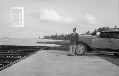 César Bustos junto a auto en muelle cabotaje, c. 1950