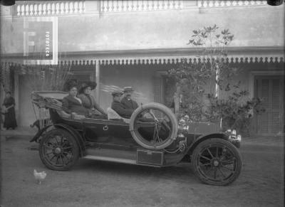 Dos señores y dos señoras en auto frente a galería casa