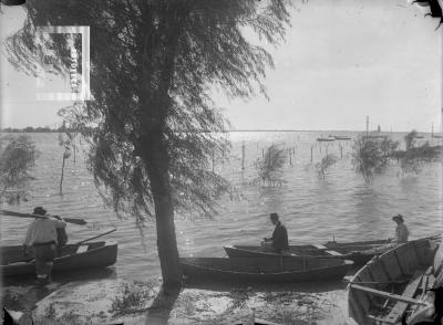 Hombre de sombrero pescando en canoa con Carlitos Bustos