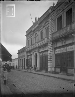 Calle Mitre en la cuadra comprendida entre Urquiza y 9 de Julio (vereda impar). Casa de alto con mástil: //Altos de Frugone// donde posteriormente funcionaron los Tribunales