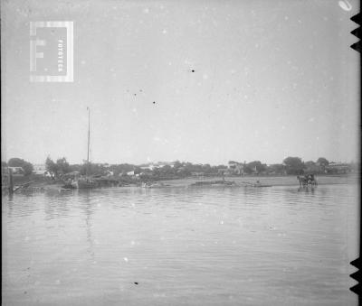 Panorámica desde el río con velero y carro a caballo