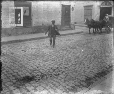 Hombre cruzando calle empedrada