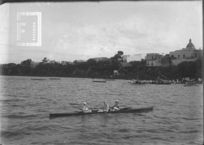 Bote doble par con timonel frente a barranca y edificios San NIcolás