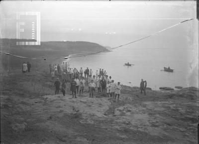 Grupo junto al río, al fondo canoas