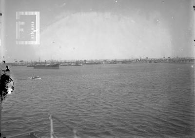 Vista panorámica del puerto, desde el río, con buques y lancha