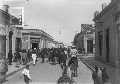 Muchedumbre de espaldas marchando por medio de la calle