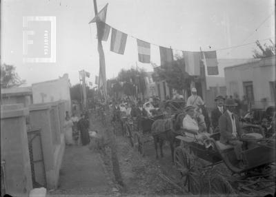 Desfile de carruajes en calle embanderada