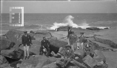 En Mar del Plata, grupo sentado en la costa